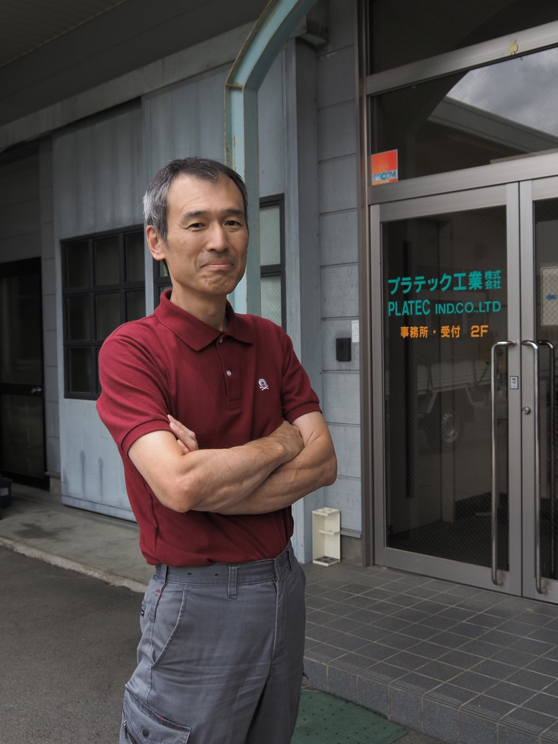 本社入口前に立つ代表取締役 今井 康弘