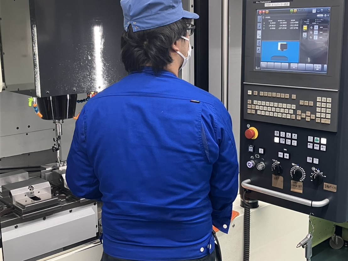 工作機械の操作パネルを扱うオペレーター
